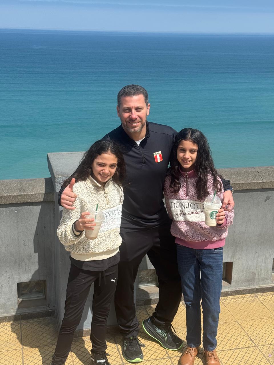 Alberto Tejada junto a sus hijas frente al mar